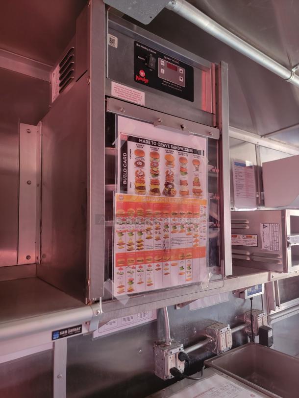 Wendy's Bun Heating Cabinet with control panel and sandwich build chart, in good condition.