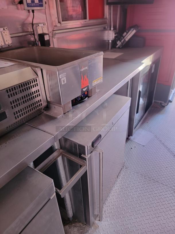 Commercial kitchen equipment with a Cayenne brand warmer on a stainless steel counter, in good condition.