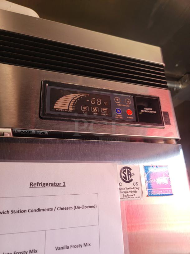 Stainless steel deluxe refrigerator with digital temperature display, CSA and Energy Star certified, featuring control panel and instructions.