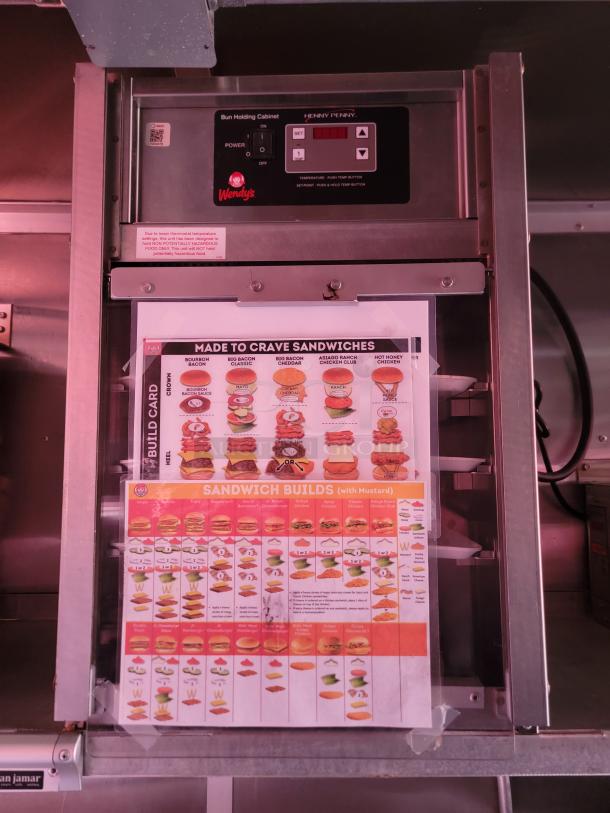 Henny Penny bun holding cabinet with Wendy's logo, featuring digital controls and sandwich build chart.