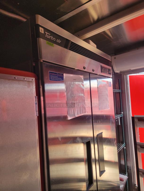Turbo Air double-door commercial refrigerator, stainless steel, features energy-efficient design, visible "Exceptional Quality" label, good condition.