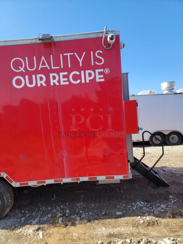 Red food trailer with "Quality is Our Recipe" text, security camera, and black entry steps. Used condition, no visible brand.