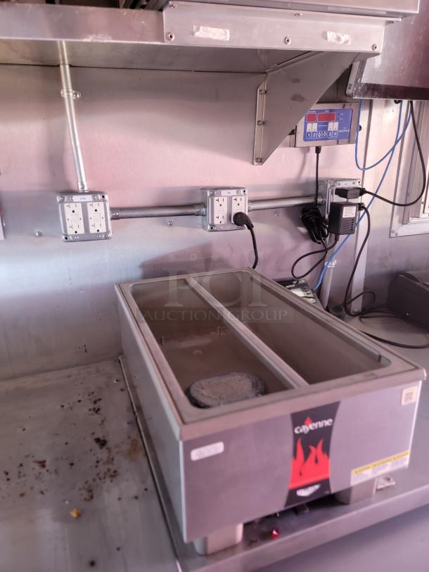 Cayenne food warmer with dual compartments, stainless steel, visible controls, and minor surface residue; electrical hook-up nearby.