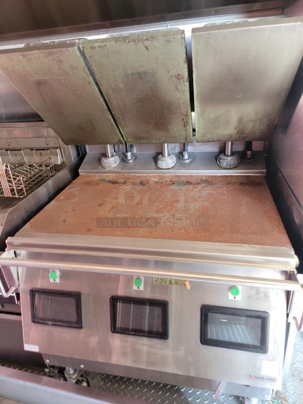 Commercial grill with three hinged cast iron lids, stainless steel construction, visible rust and wear, Groenland brand logo.