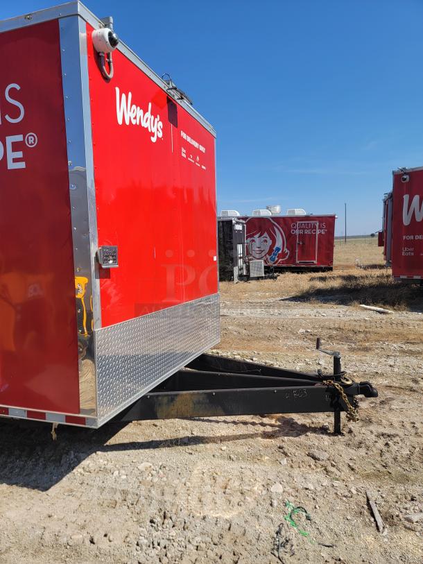 Red Wendy's mobile kitchen trailer with logo, diamond plate trim, and visible hitch. Clean exterior, ideal for food service.