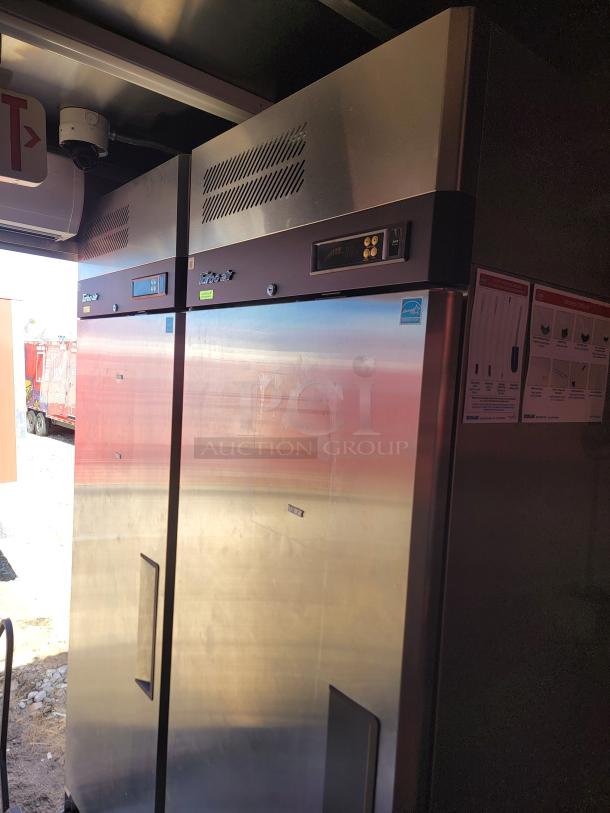 Stainless steel commercial refrigerator, double-door, with digital temperature display and ventilation grills, in good condition.