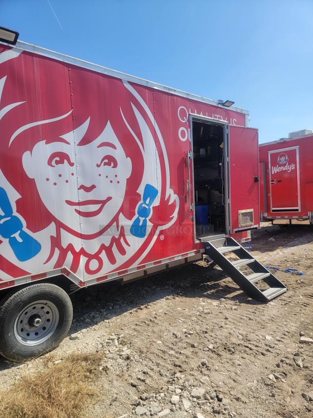 Red Wendy's mobile kitchen trailer with branding, open side door with stairs, and used condition. Visible "Quality Is Our" slogan.