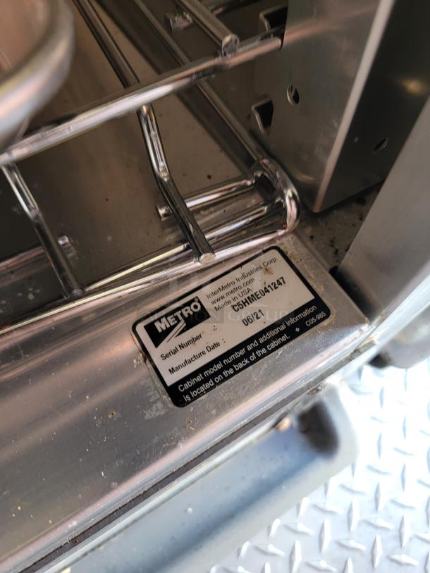 Metro stainless steel cabinet with interior shelves, featuring a label with model number C5HME04121 and manufacture date 06/21.