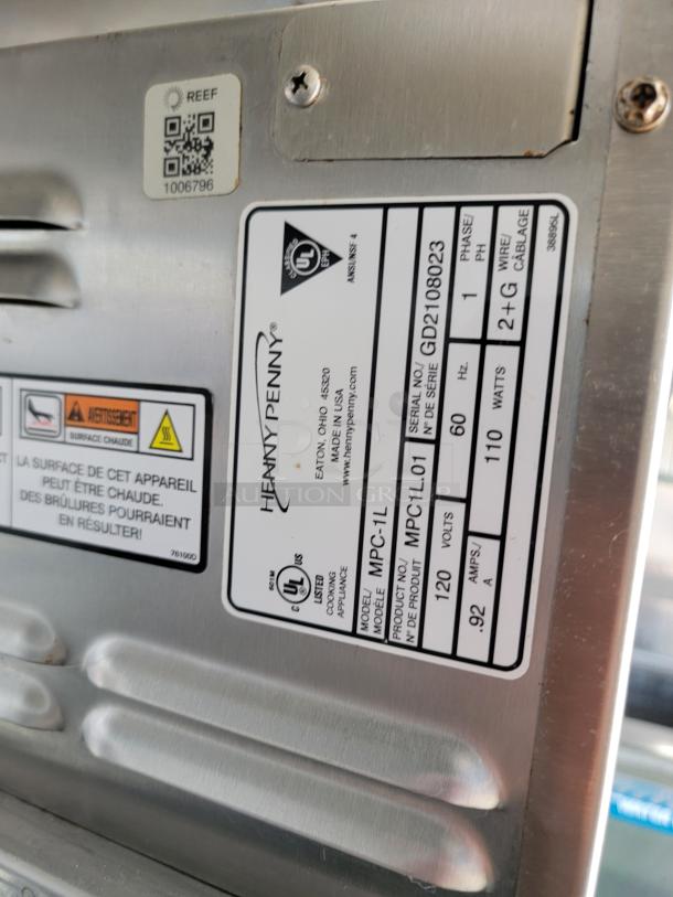 Henny Penny model MPC-1L food appliance label, serial GD2108023, 120V, 110W, in good condition with safety warnings.
