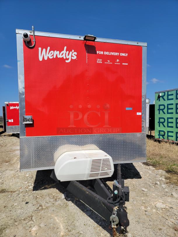 Red Wendy's delivery trailer with logos, lockable hitch, and diamond plate trim, in used condition.