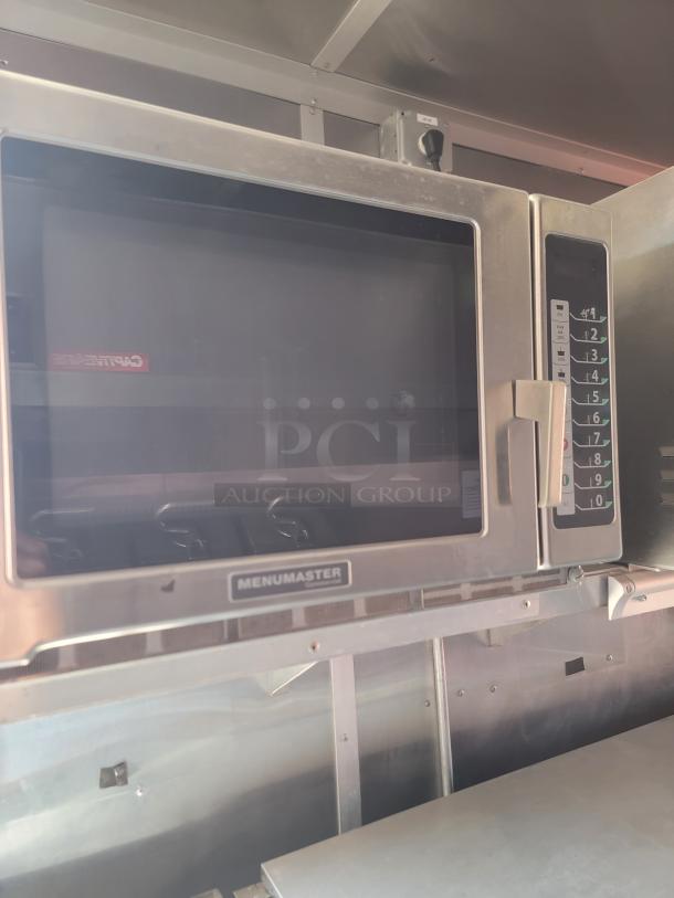 Menumaster commercial microwave with numeric keypad, stainless steel finish, visible signage, well-maintained condition.