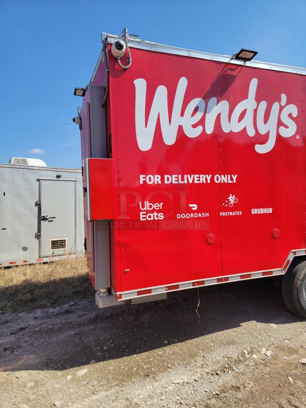 Red Wendy's delivery truck with logos for Uber Eats, DoorDash, Postmates, and Grubhub, indicating delivery-only service.