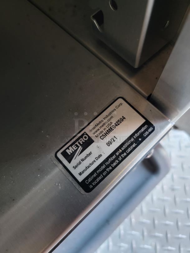 Metal cabinet with Metro label showing serial and manufacture date of 09/21. Marked as C5HMC.