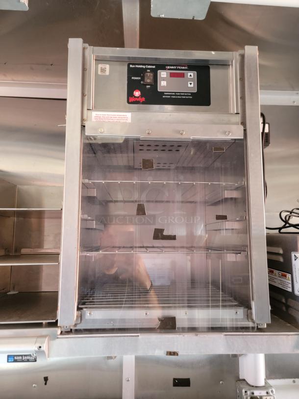 Henny Penny bun holding cabinet, stainless steel, digital controls, Wendy's branding, used condition, visible shelves.