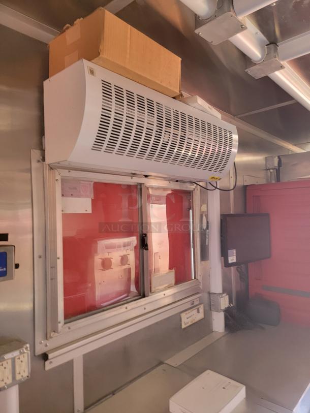 Stainless steel interior with mounted air curtain above sliding window, adjacent to control panel and monitor. Excellent condition.