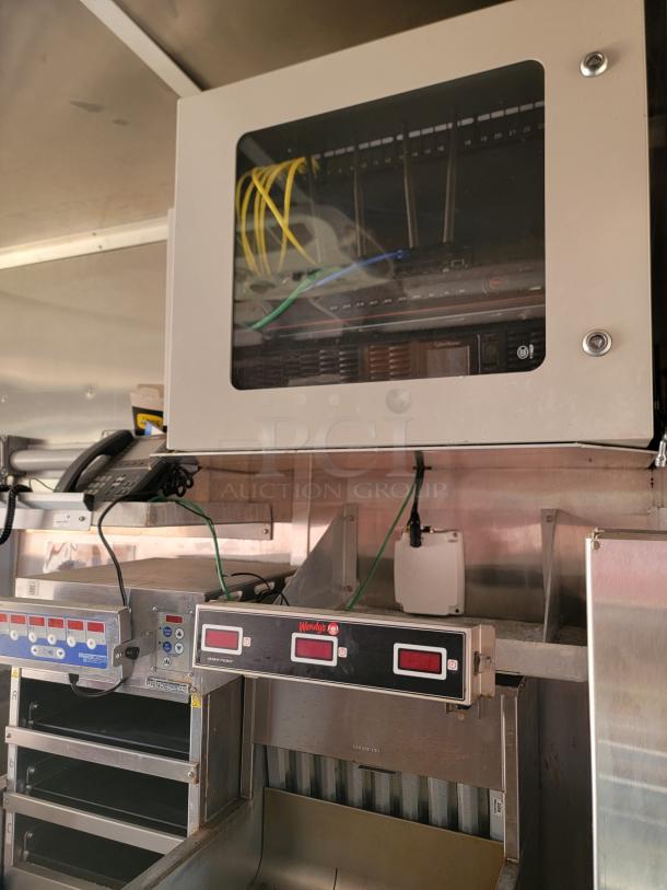 Commercial kitchen equipment with electronic control panels, showing a telecommunications cabinet and Wendy's branded timers.