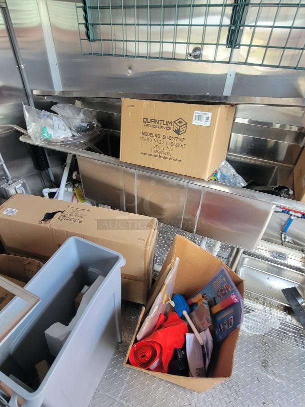 Cardboard box labeled Quantum Foodservice, model SG-B17110P, 17x28x17 inches, stainless interior, various items nearby.