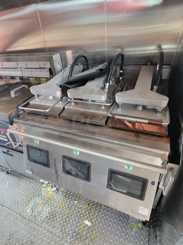 Commercial griddle with dual platens, stainless steel, digital displays. Used condition with visible wear and grease stains.