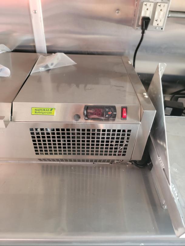Stainless steel refrigeration unit with digital display. Features "Natural Refrigerant" label. Excellent condition.