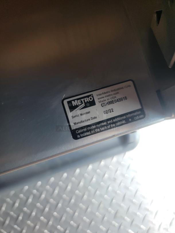 Metal equipment with Metro label showing serial number C5HME043916, manufactured 02/22, Made in USA.