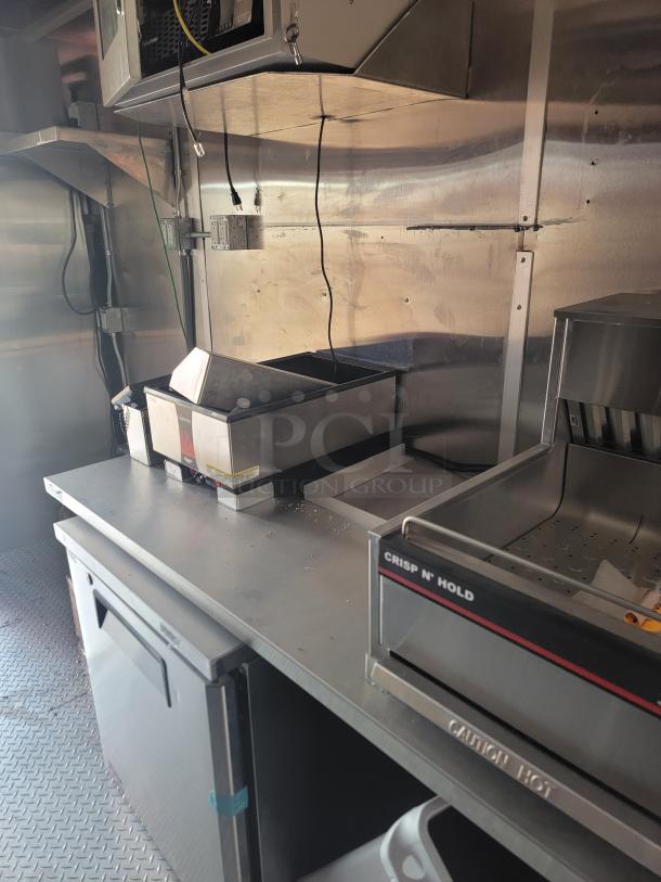 Commercial kitchen equipment with Crisp N' Hold warmer, stainless steel counter, and integrated cooling unit. Good condition.