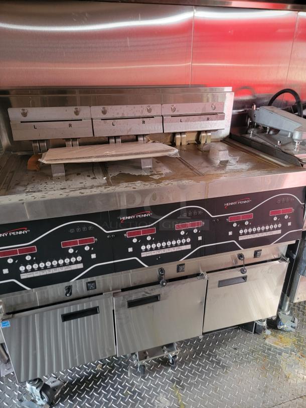 Henny Penny commercial fryer, stainless steel, multiple control panels, used condition, efficient for large-scale cooking.