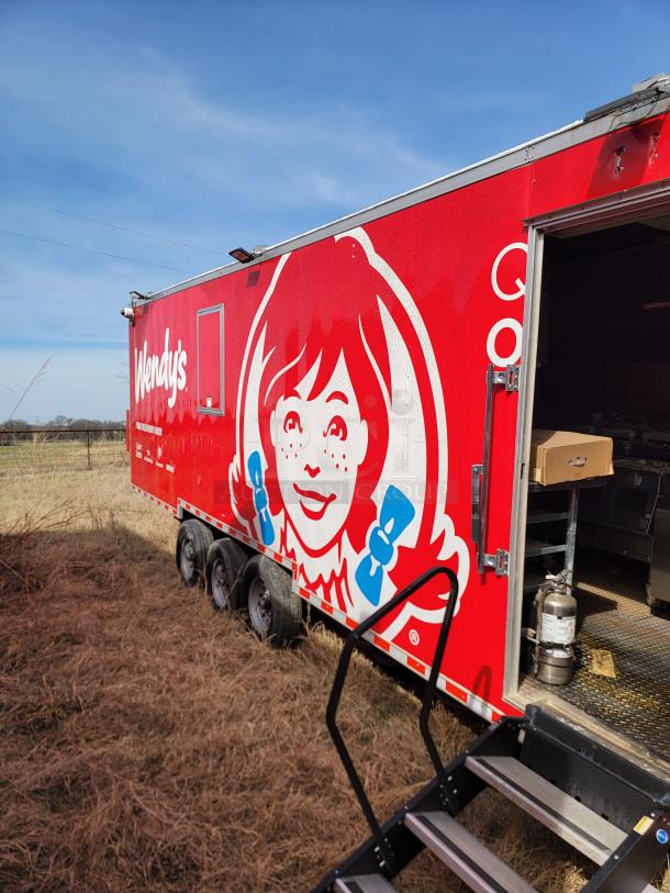 Wendy's branded food trailer, red exterior, side entry with metal staircase, well-maintained condition, visible fire extinguisher inside.
