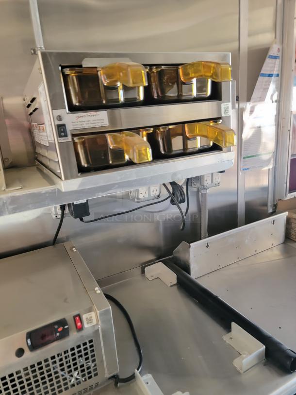 Commercial food warmer with two tiers, featuring amber lids and stainless steel construction. Appears in excellent condition.