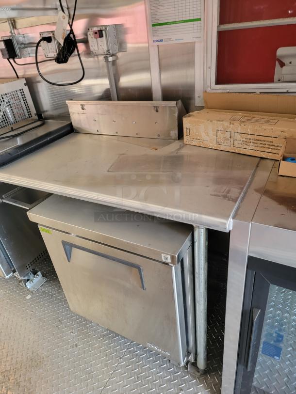 Commercial stainless steel prep table with storage, good condition, features integrated power outlets and Ecolab control panel.
