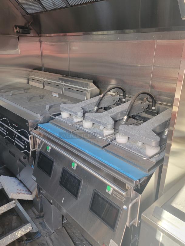 Industrial kitchen equipment with stainless steel finish, featuring multiple fryers with digital displays, in excellent condition.