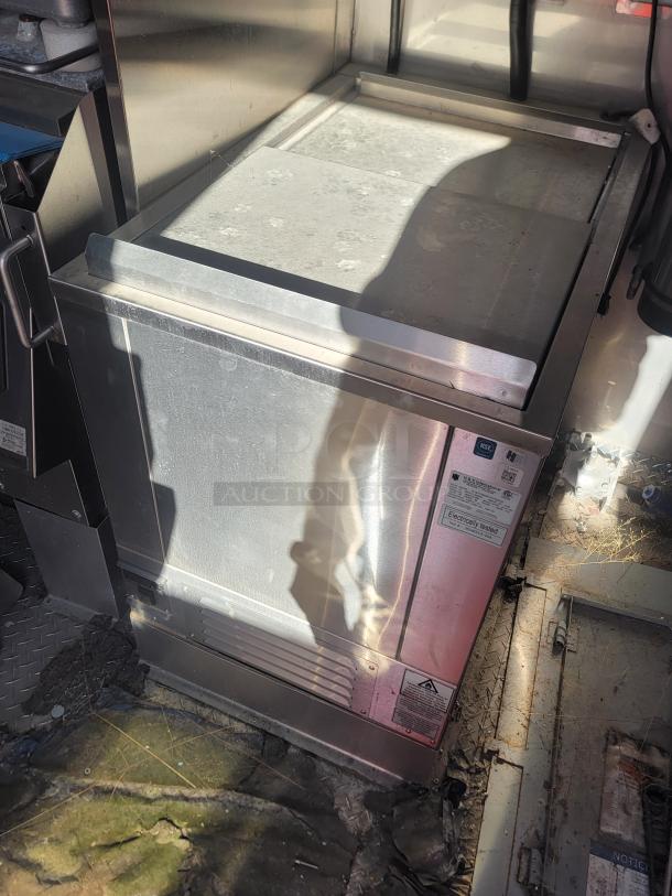Commercial stainless steel refrigerator unit with sliding top, used condition, showing manufacturer's labels and electrical testing mark.