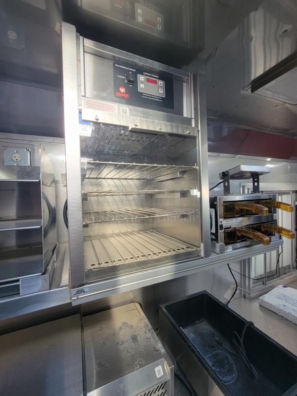 Stainless steel commercial warming cabinet, featuring multiple racks and digital controls, branded with Wendy's logo.