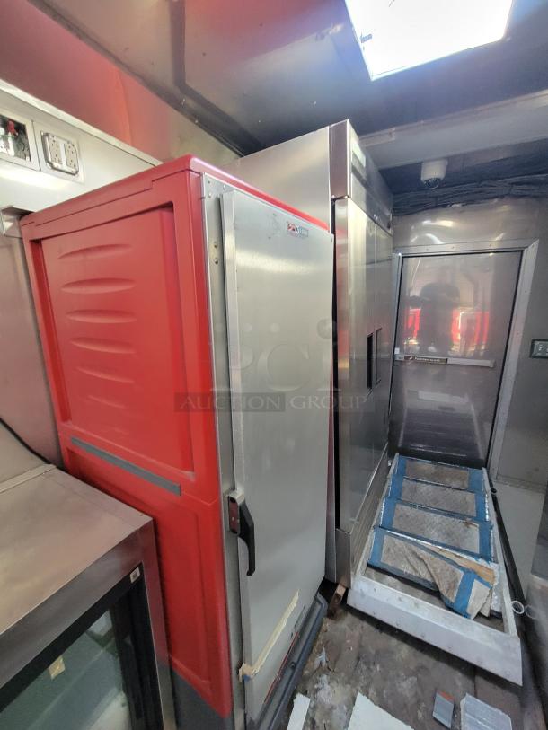 Commercial stainless steel refrigeration units and red storage cabinet in used condition. No visible branding or VIN.