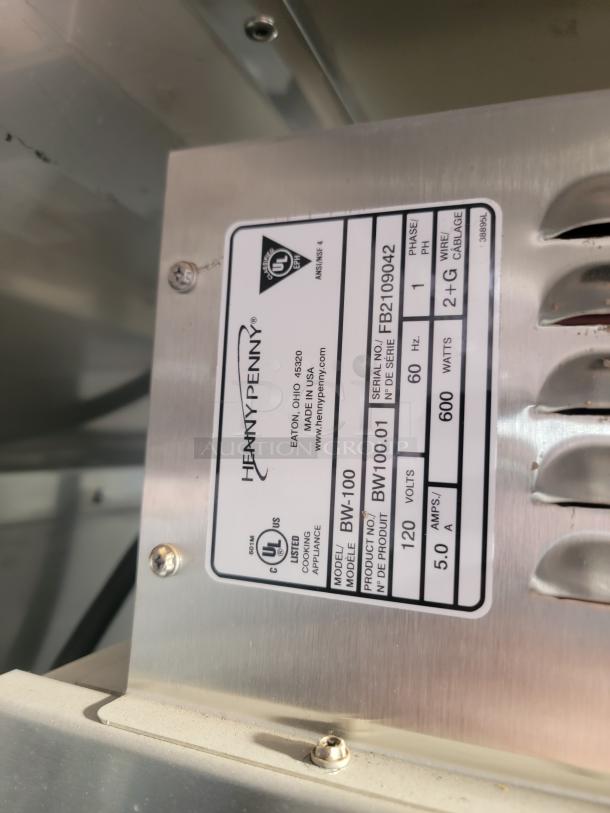 Henny Penny BW-100 cooking appliance label showing model BW-100, serial FB2109042, 120V, 600W, 5.0A, Phase 1.