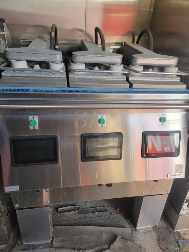Stainless steel commercial kitchen equipment with dual grills, control panels, and visible Garland branding. Used condition.