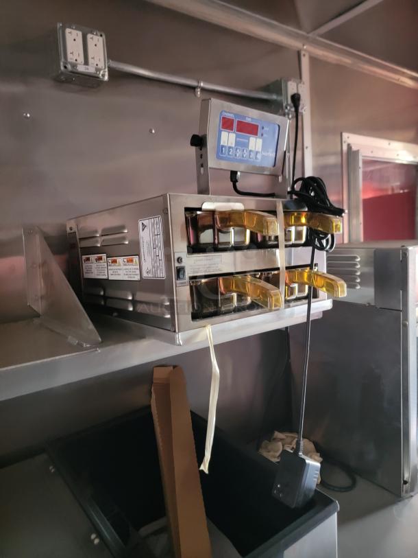 Stainless steel commercial oven with digital control panel and multiple settings, mounted on a shelf.