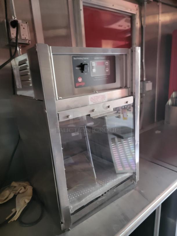 Stainless steel bun holding cabinet with Wendy's logo, temperature controls, and clear glass front in used condition.