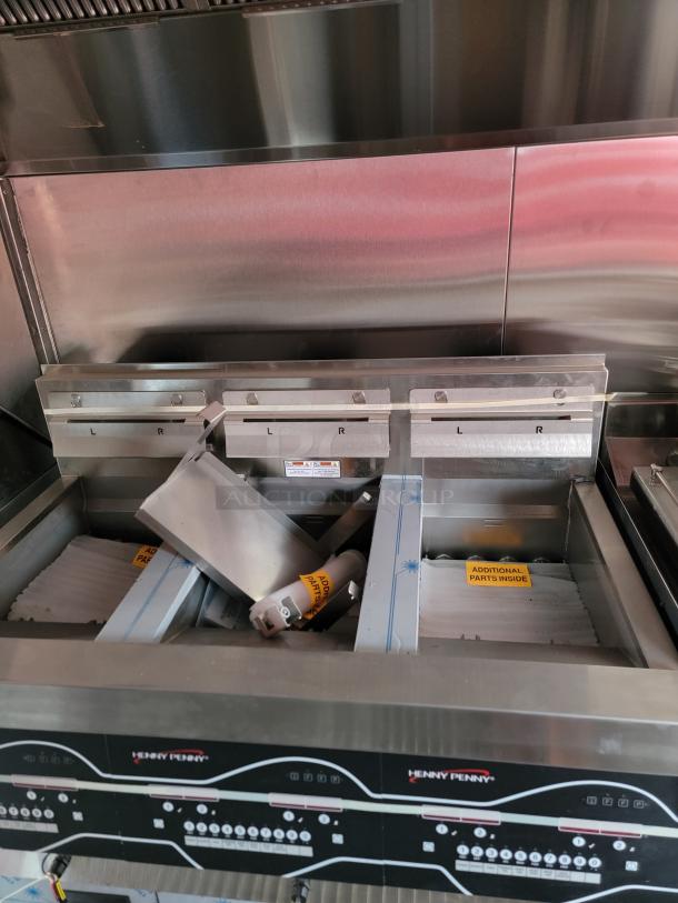 Henny Penny commercial fryer, stainless steel, with multiple compartments, labeled "Additional Parts Inside," clean condition.