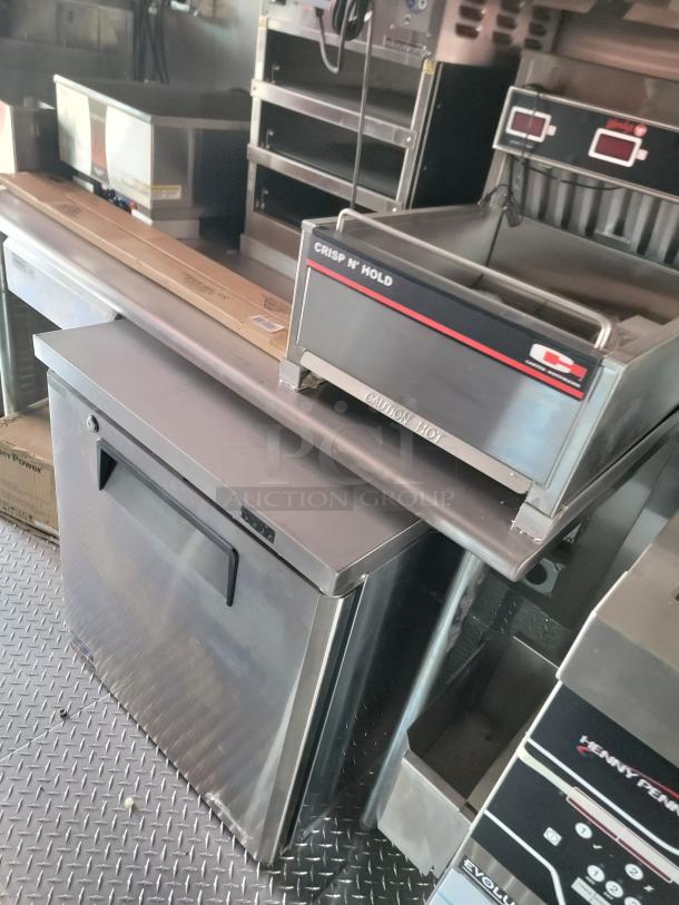 Commercial kitchen appliances, including a Crisp N' Hold unit and Evolution model, in stainless steel. Appears in good condition.