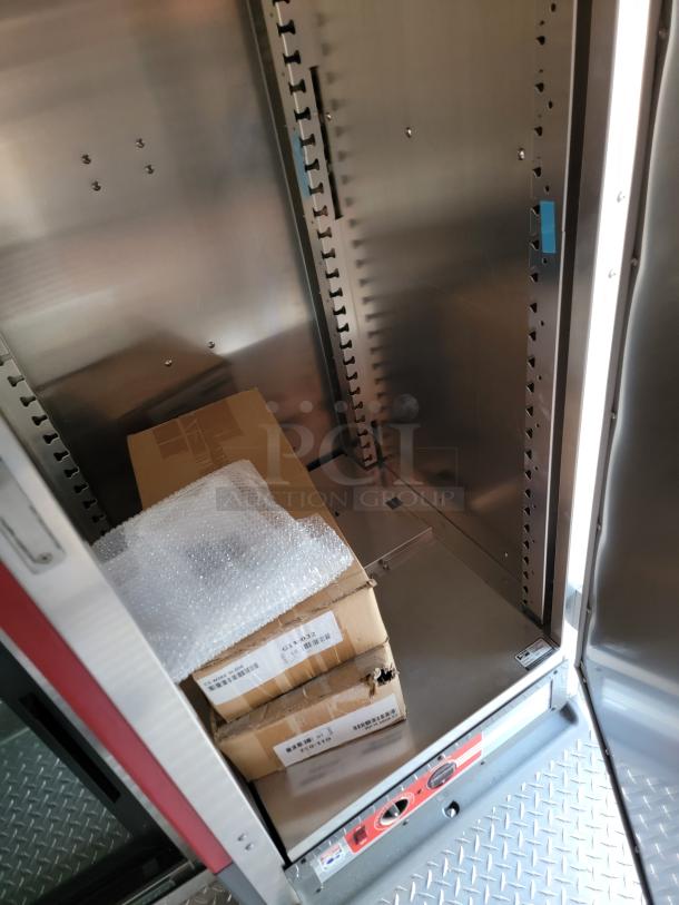 Metal storage cabinet interior with adjustable shelves; includes cardboard boxes with labels, wrapped in bubble wrap.