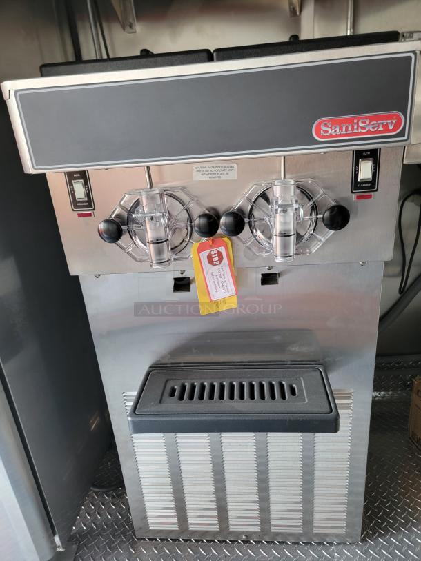 SaniServ ice cream machine, stainless steel, dual dispensers, auto/cleanout switches, "Stop" tag attached, excellent condition.
