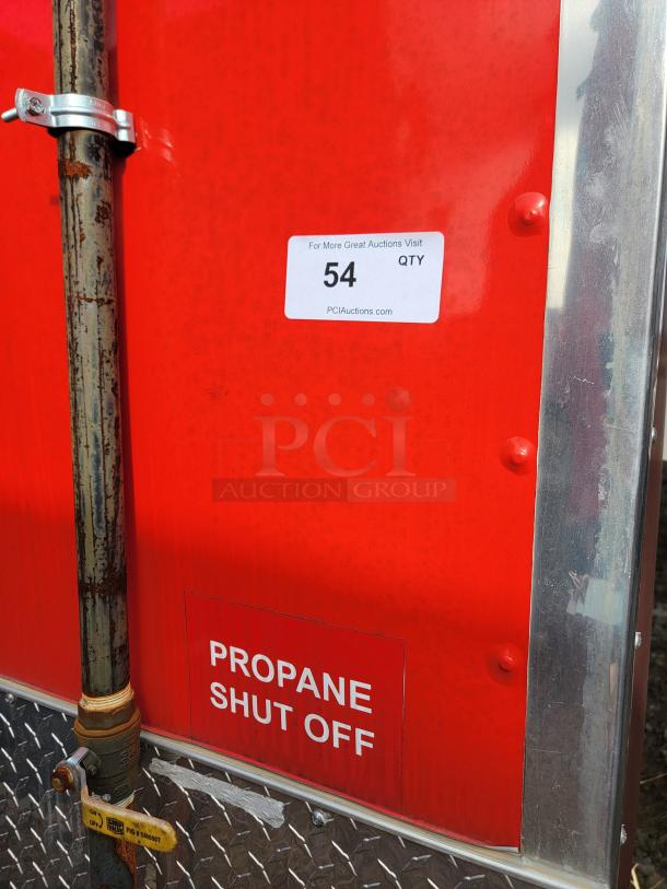 Red metal panel with propane shut-off valve; labeled "Propane Shut Off" and auction tag "54" from PCIAuctions.com.
