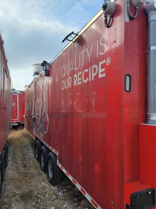 Red commercial trailer with "Quality is Our Recipe" slogan, multiple security cameras, and triple axles, indicating durability.