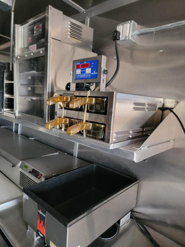 Commercial stainless steel multi-burner fryer with digital control panel. Includes Coyote branded warming unit. Appears in excellent condition.