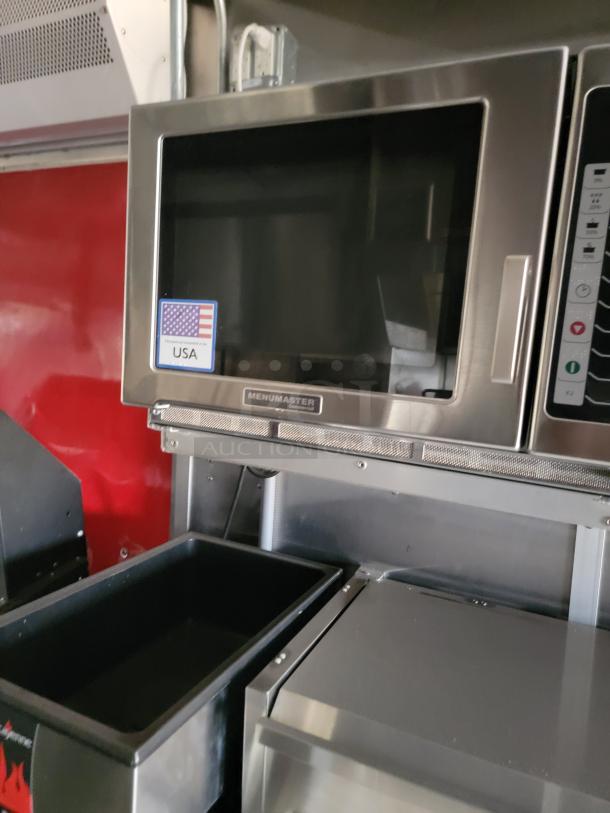 Menumaster microwave oven in stainless steel with USA label, clean condition, mounted in a metal kitchen setup.