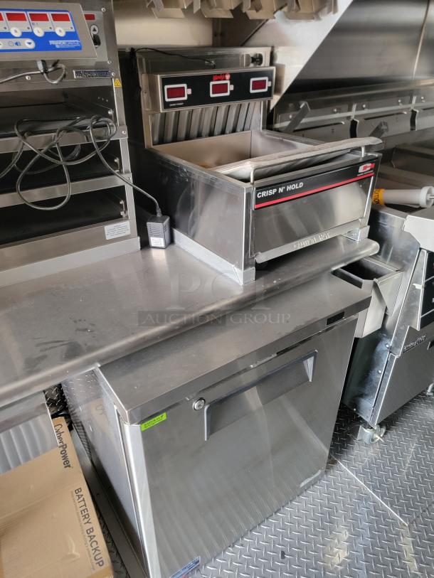 Commercial kitchen setup featuring Crisp N' Hold food warmer, FingerCrisp controller, and stainless steel counter.
