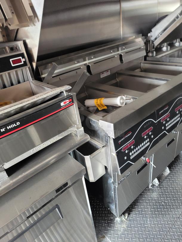 Commercial kitchen equipment featuring Henny Penny Evolution fryers with digital controls and stainless steel body, in excellent condition.