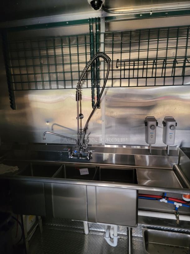 Commercial stainless steel three-compartment sink with high-arc faucet and integrated soap dispensers, in excellent condition.