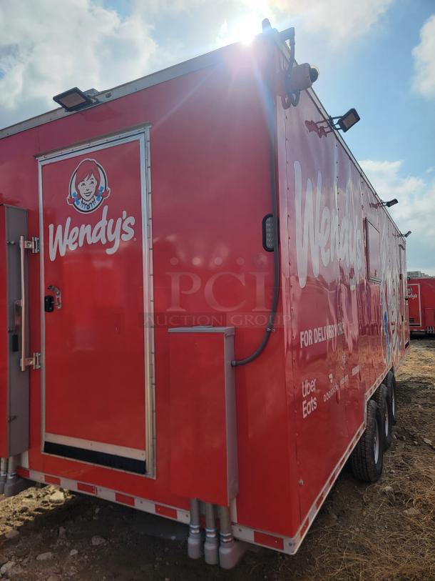 Red Wendy's promotional trailer with brand logo, delivery service logos, and rear access door, in used condition.