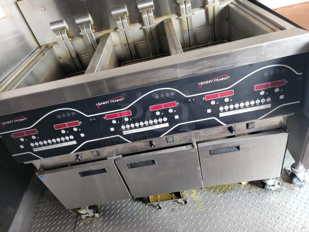 Henny Penny commercial fryer, four-slot model, stainless steel, good used condition, digital controls visible on panel.